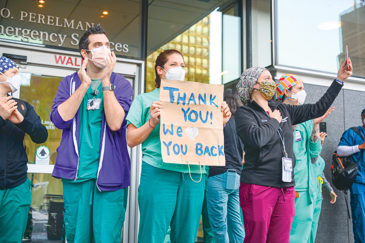 NEW YORK, NEW YORK - MAY 01: Medical workers hold a thank you sign outside NYU Langone Health hospital as people applaud to show their gratitude to medical staff and essential workers during the coronavirus pandemic on May 1, 2020 in New York City. COVID-19 has spread to most countries around the world, claiming over 239,000 lives with over 3.4 million infections reported. (Photo by Noam Galai/Getty Images)