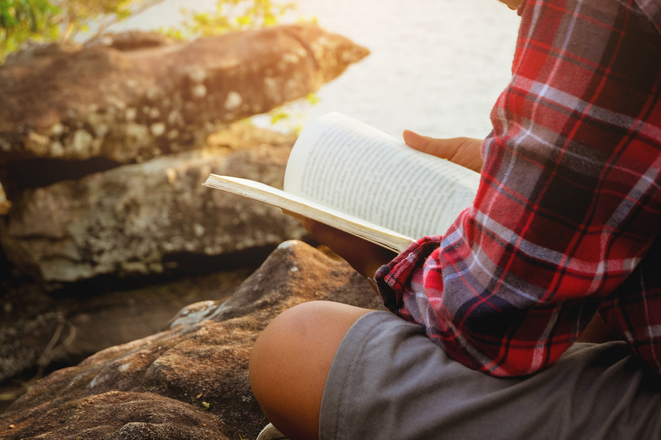 Relaxing moments, Young boy reading a book by the lake. Relax time on holiday concept travel, Thailand. Color of Hipster Tone. (Relaxing moments, Young boy reading a book by the lake. Relax time on holiday concept travel, Thailand. Color of Hipster To