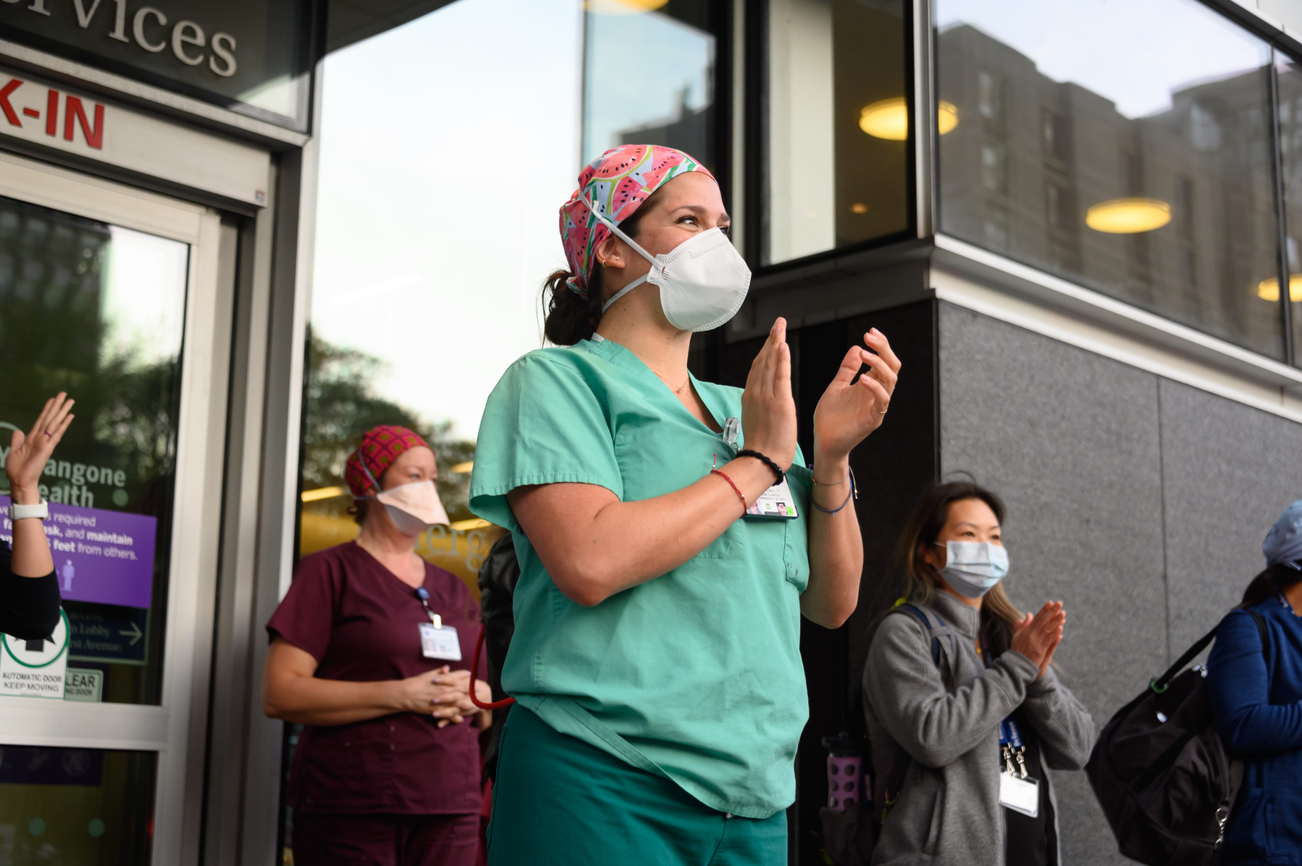 NEW YORK, NEW YORK - MAY 19: Medical workers wearing protective masks stand outside NYU Langone Health hospital as people applaud to show their gratitude to medical staff and essential workers during the coronavirus pandemic on May 19, 2020 in New York City. COVID-19 has spread to most countries around the world, claiming over 324,000 lives with over 4.9 million infections reported.