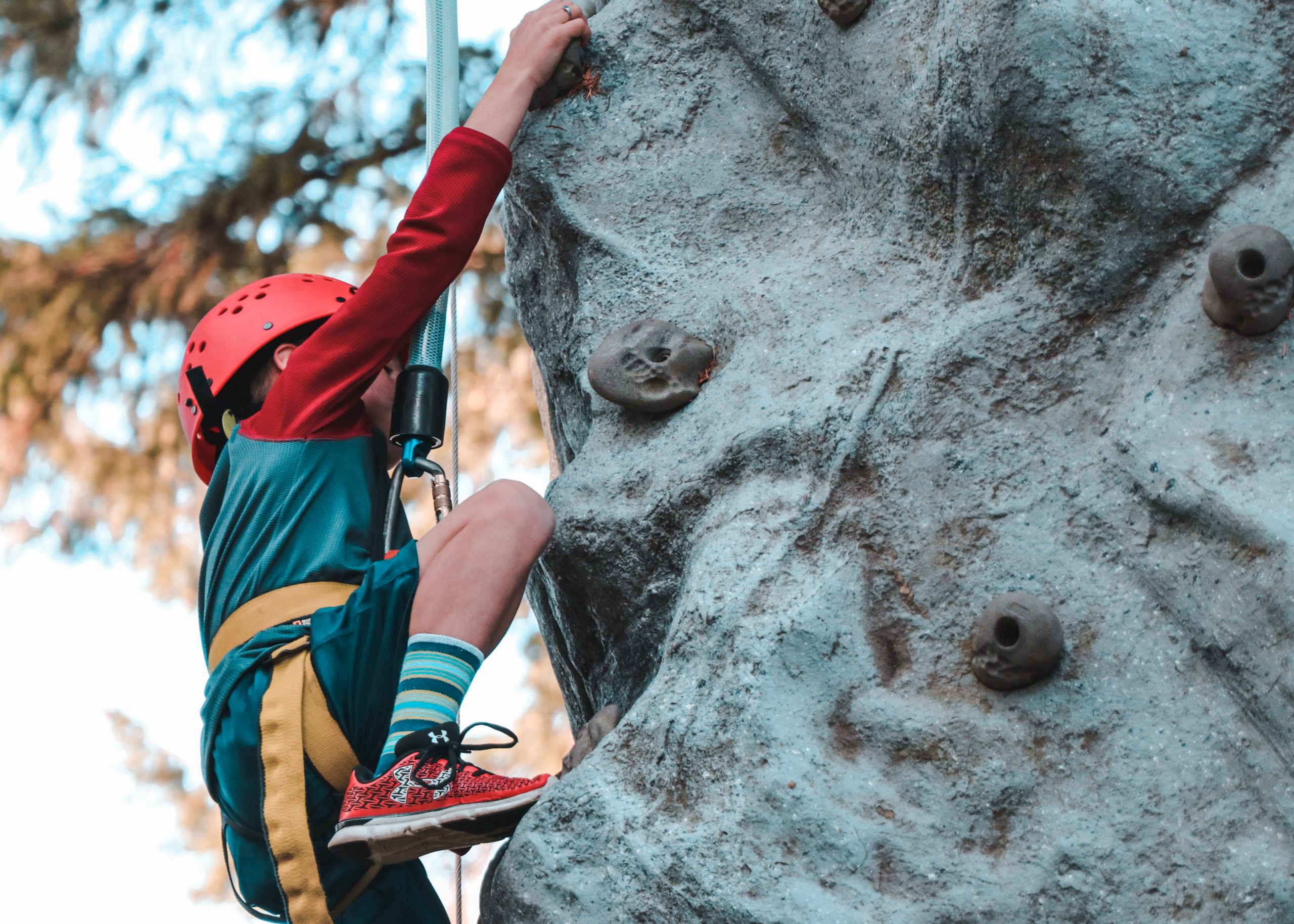 person climbing on gray rock