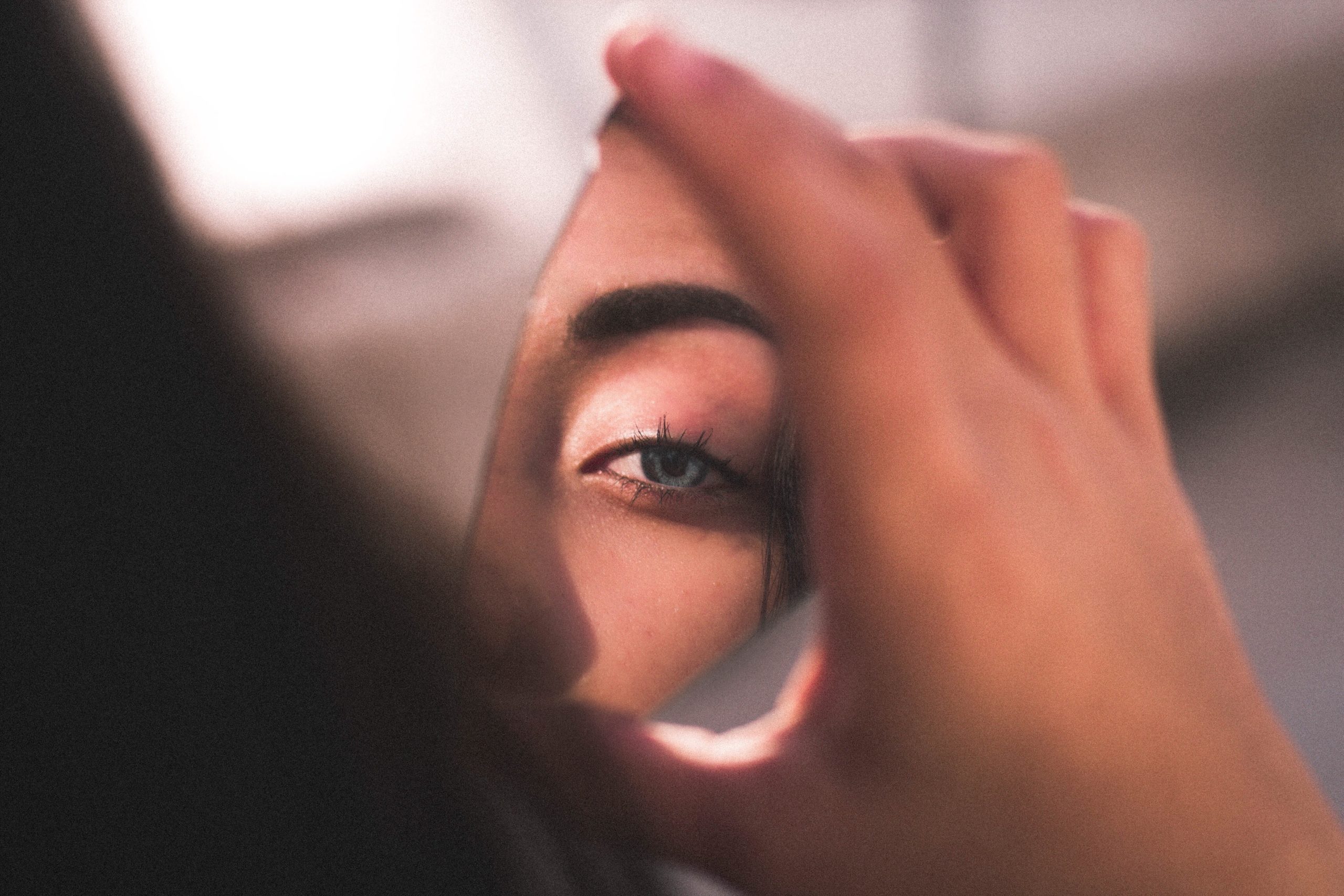 Reflection of a woman's eye in a broken mirror