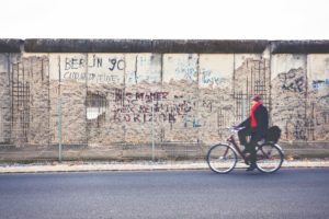 Berlin, Germany - November 16, 2011: Man cycling along the last remains of the Berlin wall along the ex headquarters of the Gestapo and the SS in Niederkirchnerstrasse.