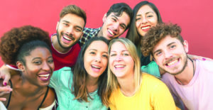 Group multiracial people having fun outdoor - Happy mixed race friends sharing time together - Youth millennial generation and multiethnic teenagers lifestyle concept - Red Background