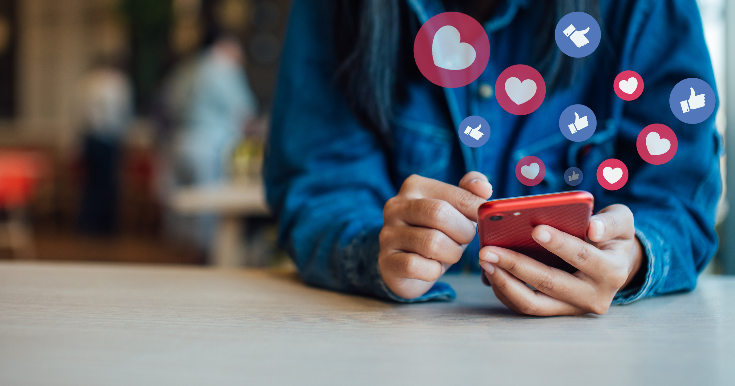 Woman Using Smart Phone On Table In Cafe