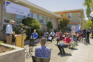 Councilmember Dan Kalb speaks at the unveiling ceremony of “Daisaku Ikeda Way” and is joined by SGI-USA representatives, Oakland, Calif., May 3, 2021. (Insets) The new street sign bearing Ikeda Sensei’s name and the accompanying proclamation from the city of Oakland.