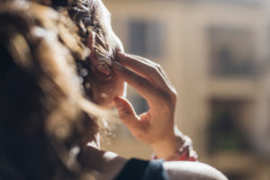 Woman listening music through wireless in-ear headphones