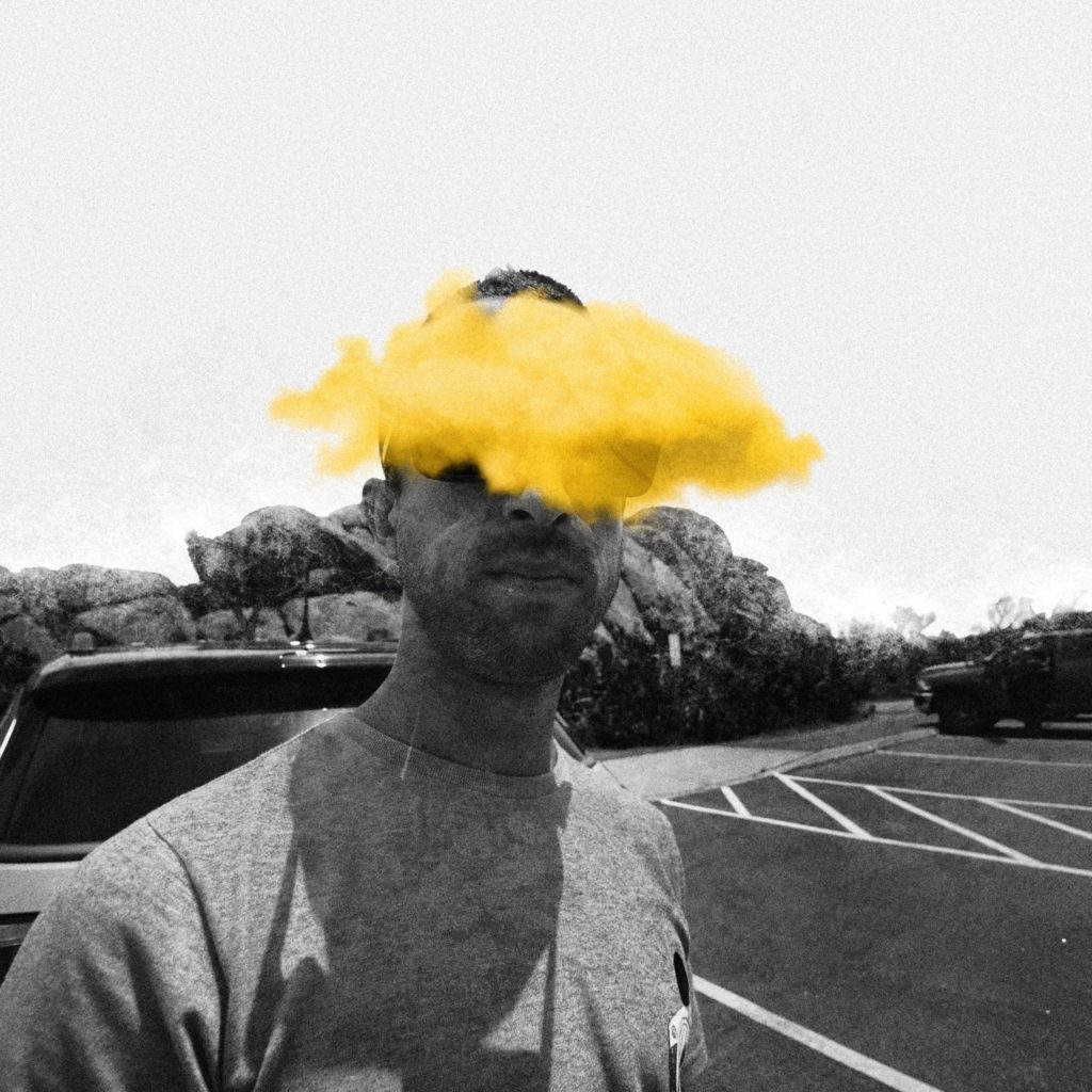 Photo of person with a yellow paintbrush over a black and white image