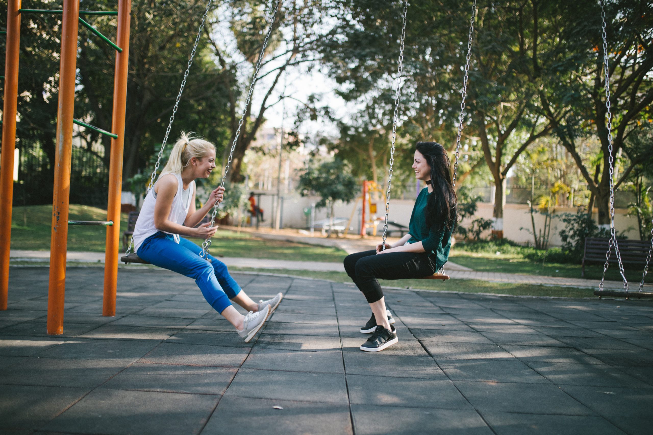 Two people on swings smiling